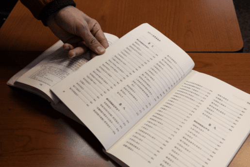 Changwu Wang flips through two foundational Chinese medicinal texts at the Pacific College of Health and Science.